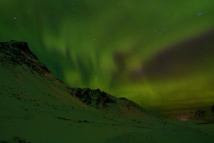 Der in grünes Nordlicht gehüllte Himmel außerhalb von Akureyri in Nordisland.