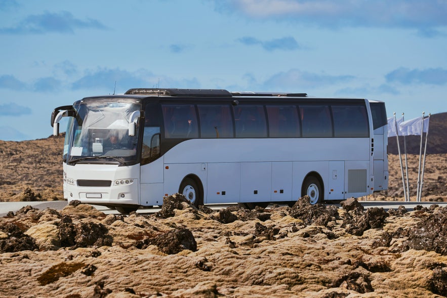 Naar de Blue Lagoon in IJsland rijden. Foto van een shuttlebus in een lavaveld.